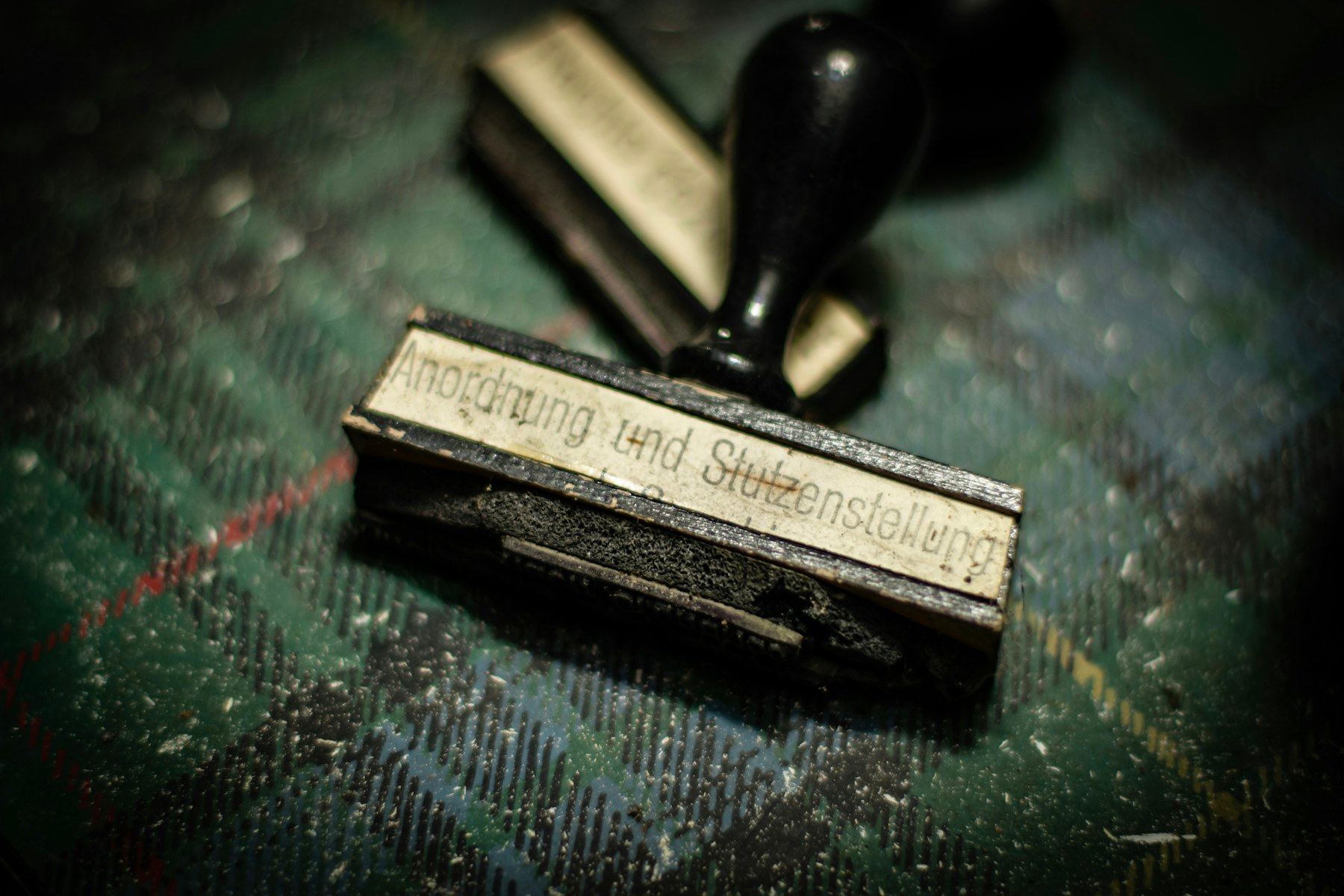 Stempel karet bergagang hitam di atas meja berlapis kain gelap